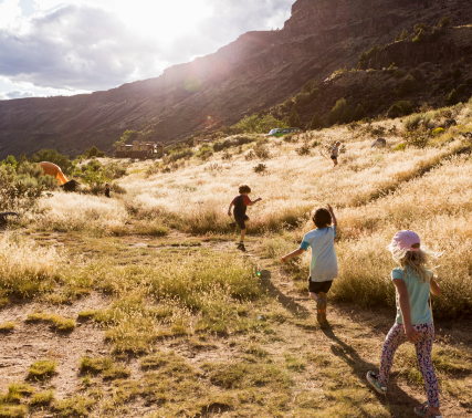 Three kids walking with mountains in the background